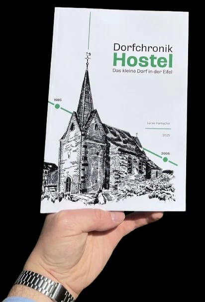 Eine Hand hält die Dorfchronik Hostel. Auf dem Titel eine Zeichnung der Kapelle und der Schriftzug „Dorfchronik Hostel – Das kleine Dorf in der Eifel“.