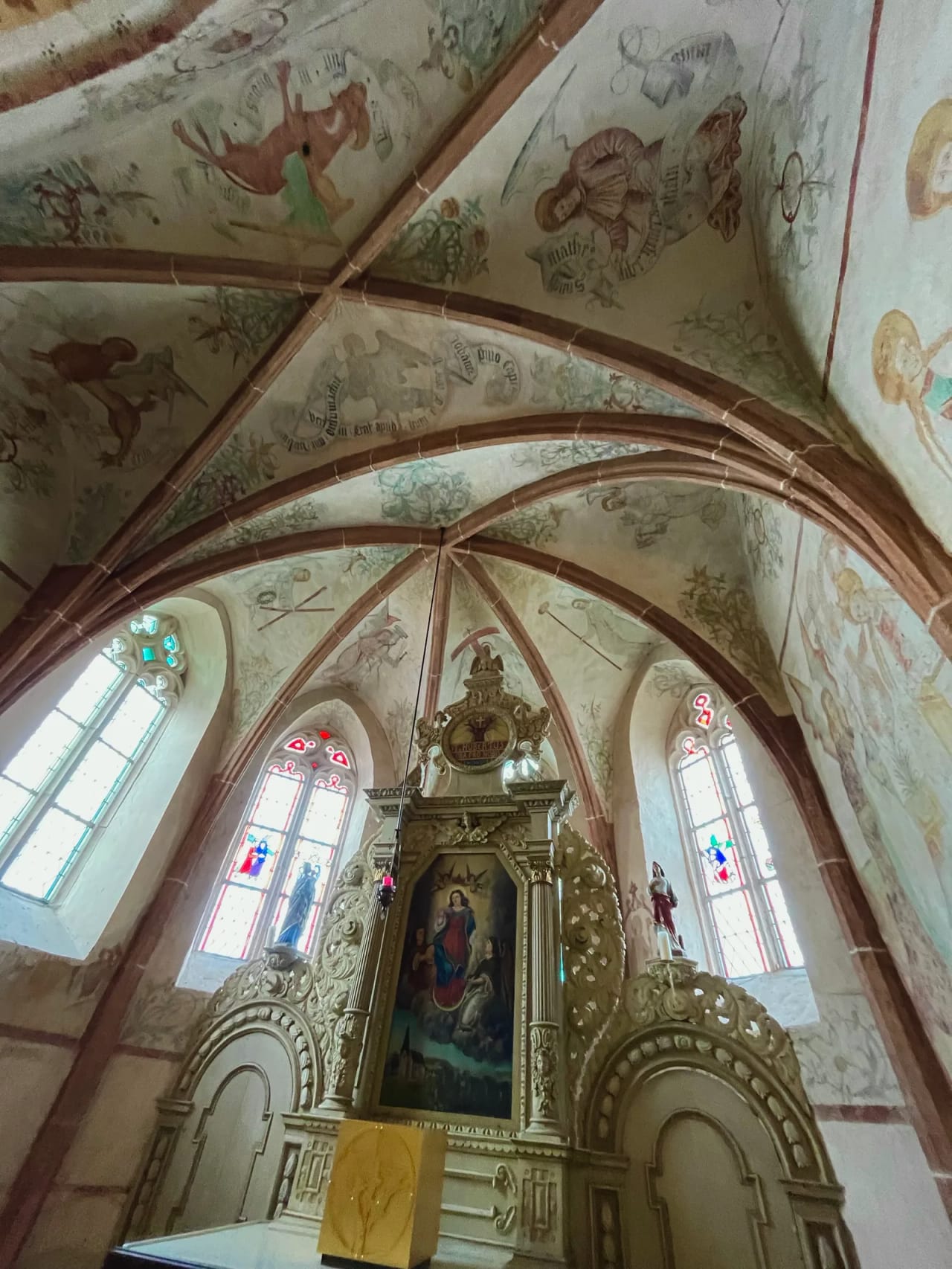 Blick ins Gewölbe der Kapelle mit mittelalterlichen Fresken über dem goldverzierten Altar