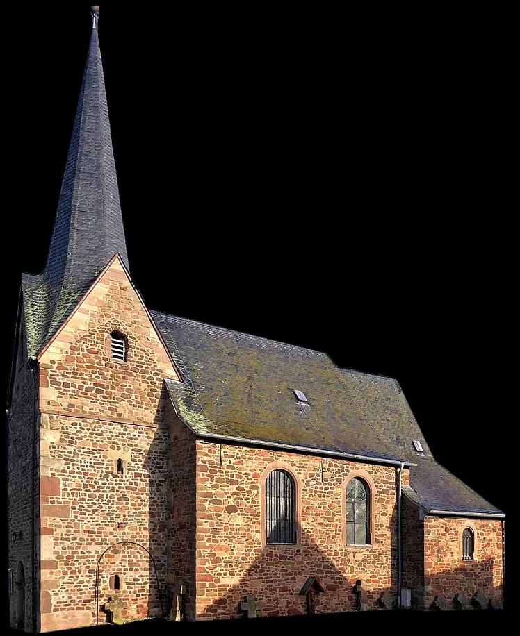 Die Kapelle von außen: Mauerwerk aus rötlichem Sandstein, ein spitzer Turmhelm aus Schiefer und kleine Rundbogenfenster