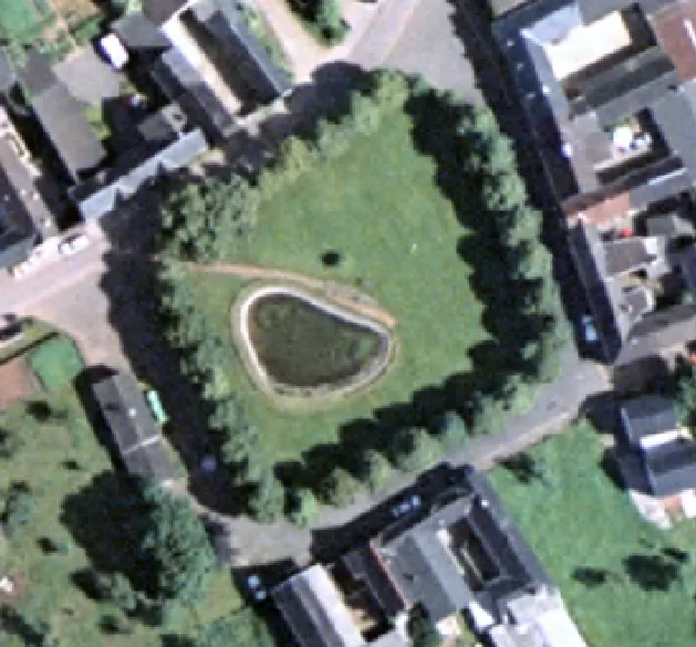 Luftbild des Dorfangers von 1998 mit dem Teich in der Mitte, umgeben von Bäumen und Fachwerkhäusern