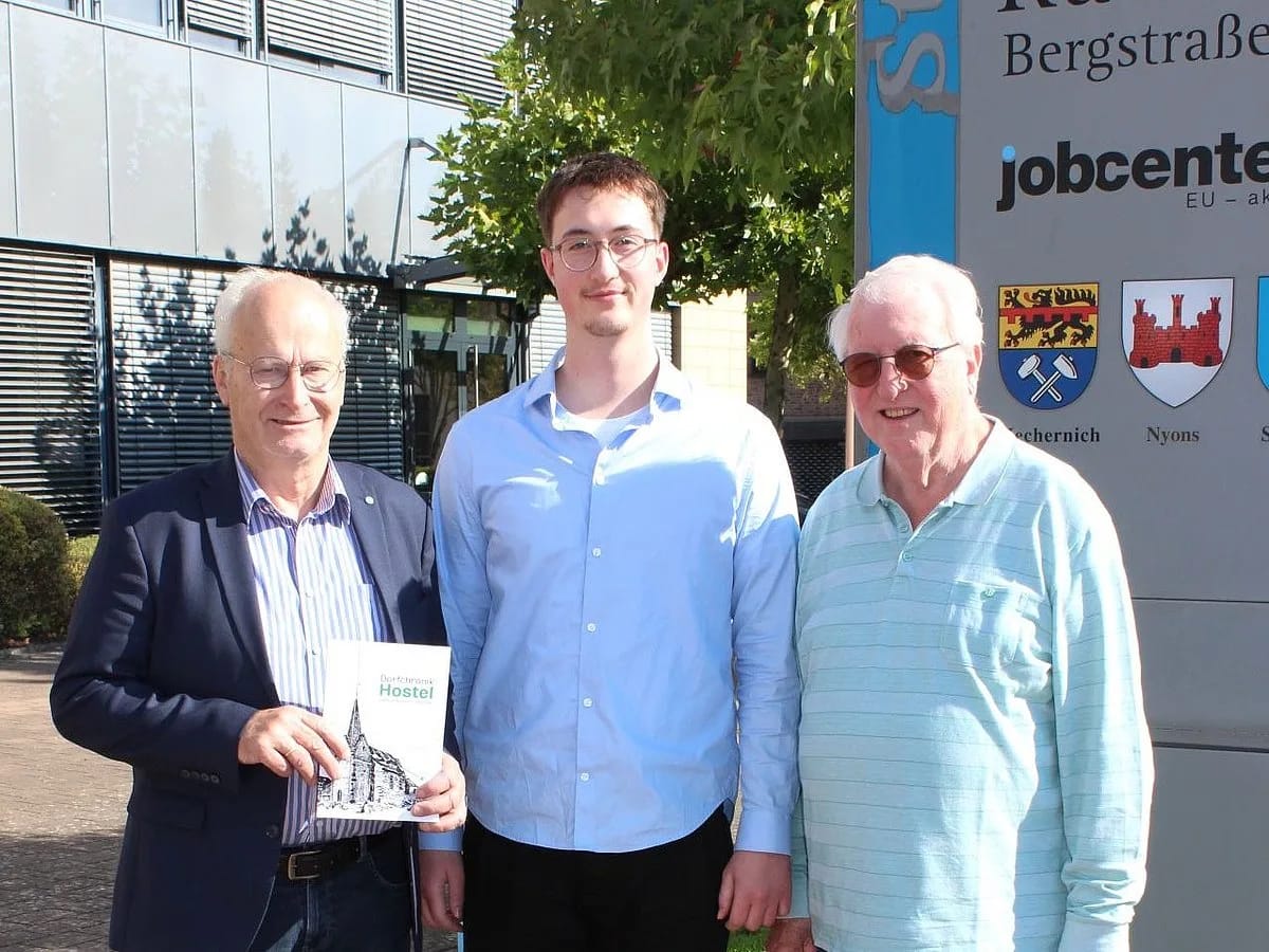 Drei Männer mit einem Exemplar der Dorfchronik vor dem Mechernicher Rathaus: links Bürgermeister Dr. Hans-Peter Schick, in der Mitte Lucas Hamacher, rechts Dieter Schröder